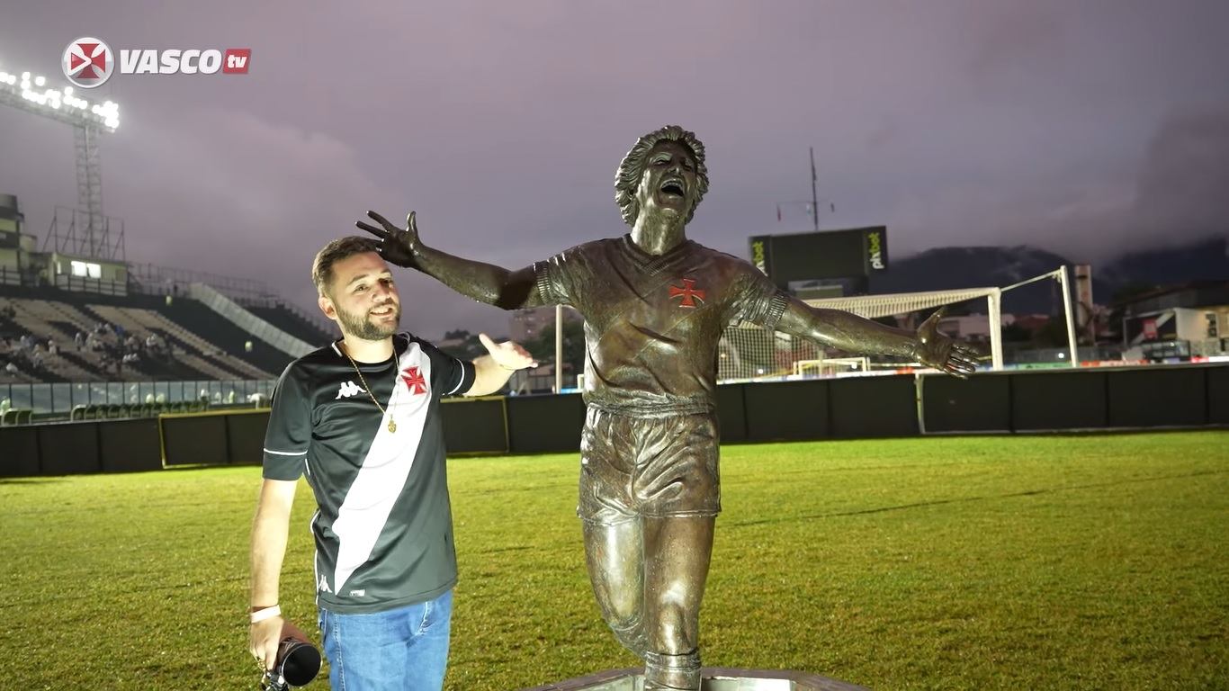 Natan posa ao lado da estátua de Dinamite em São Januário