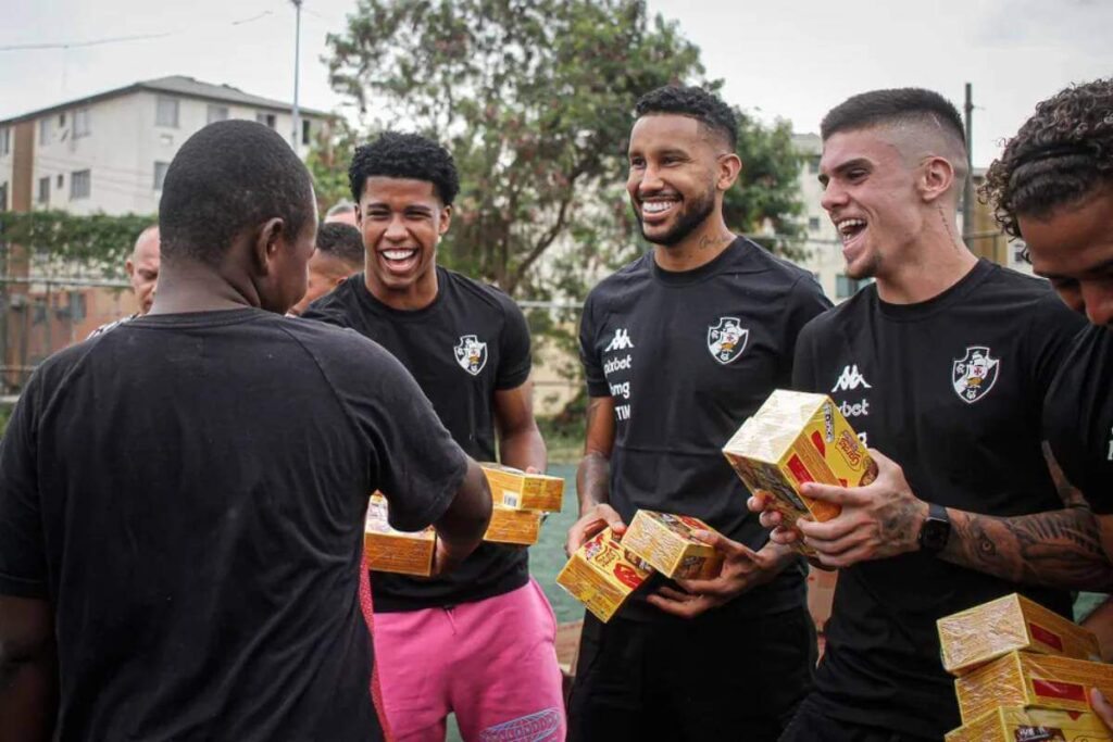 Andrey, Jair e Pec distribuem chocolates a Cidade de Deus