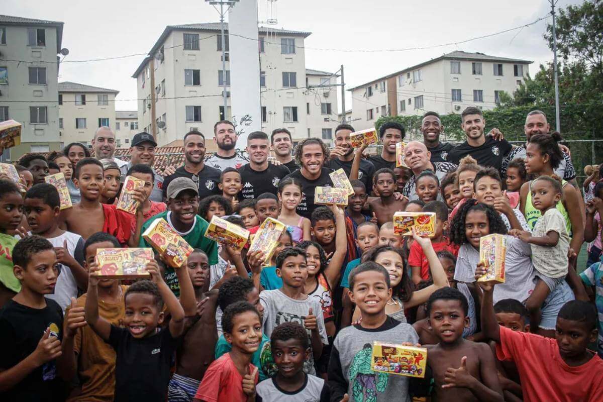Jogadores do Vasco distribuem chocolates a Cidade de Deus