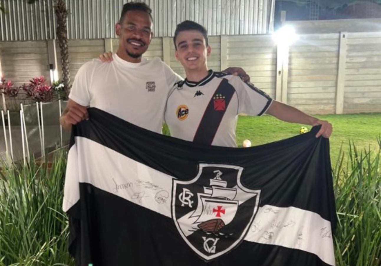Fernando posa ao lado de torcedor e com a bandeira do Vasco