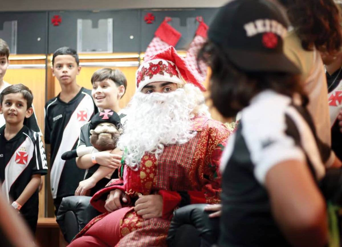 Puma vestido de Papai Noel com crianças do Vasco